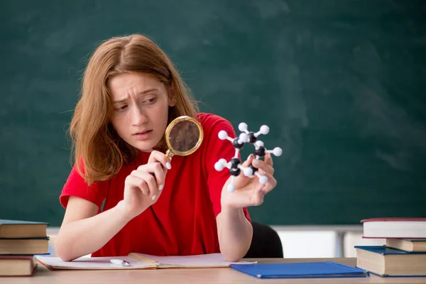 Ung kvinnlig student kemist förbereder sig för tentor i klassrummet — Stockfoto