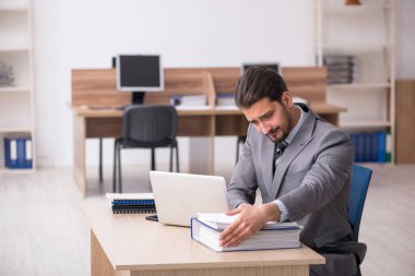 Ofiste çalışan genç bir erkek.