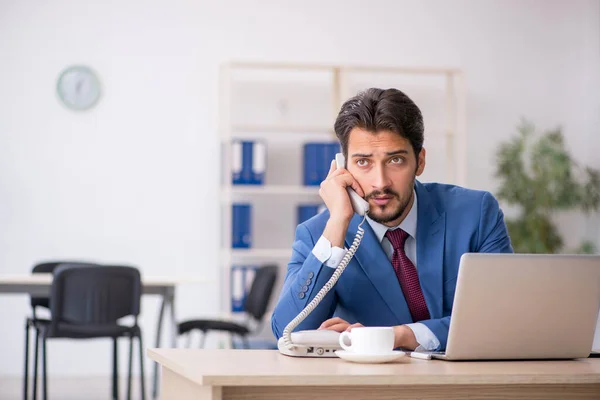 Jeune employé masculin assis sur le lieu de travail — Photo