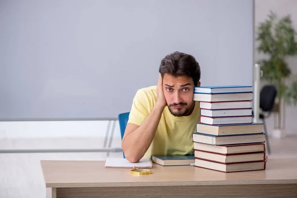 Giovane studente maschio che si prepara per gli esami in classe — Foto Stock