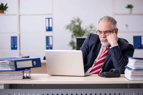 Vecchio dipendente maschile seduto sul posto di lavoro — Foto Stock