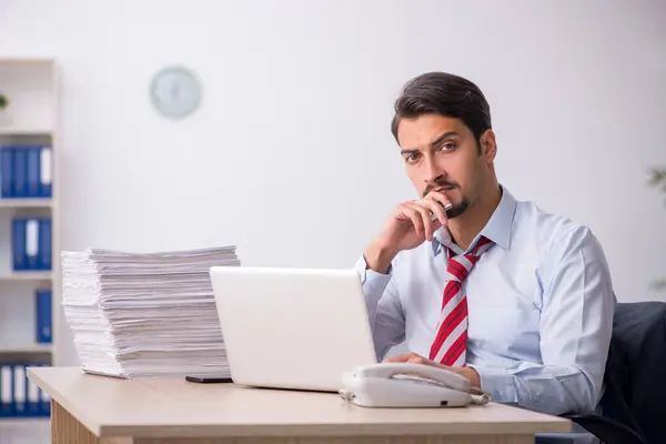 Empleado joven sentado en el lugar de trabajo — Foto de Stock