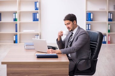 Molada kahve içen genç bir erkek.