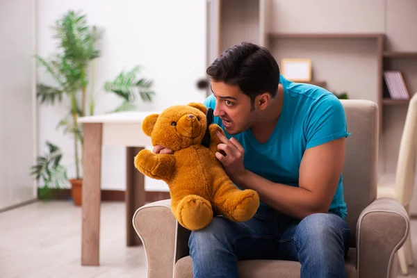坐在家里玩熊玩具的年轻人 — 图库照片