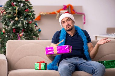 Genç adam Noel 'i evde kutluyor.