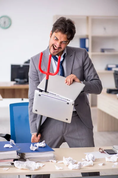 Young male employee and too much work in the office — Stock Photo, Image