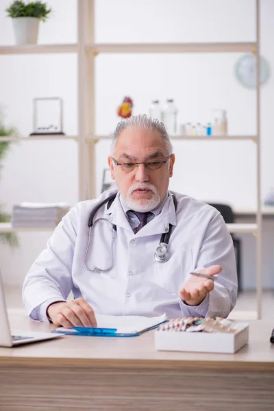 Viejo médico que trabaja en la clínica — Foto de Stock