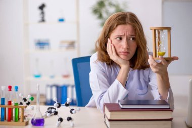 Zaman yönetimi konseptinde genç bayan kimyager.