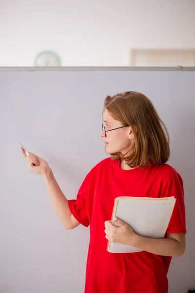 Ung kvinnlig student förbereder sig för tentor i klassrummet — Stockfoto