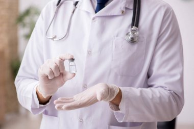 Aşı konseptinde genç bir erkek doktor.