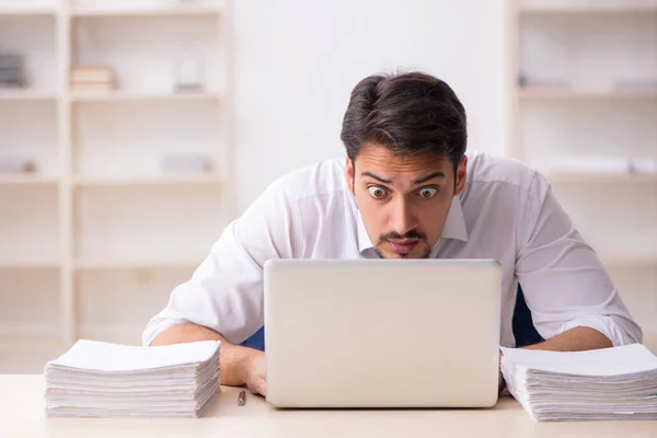 Jeune employé masculin mécontent du travail excessif au bureau — Photo