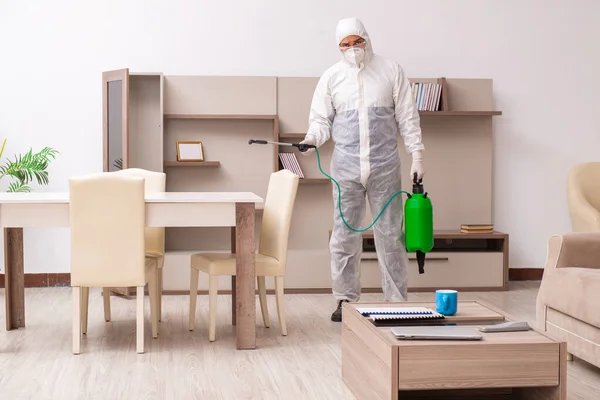 Jovem empreiteiro fazendo controle de pragas em casa — Fotografia de Stock