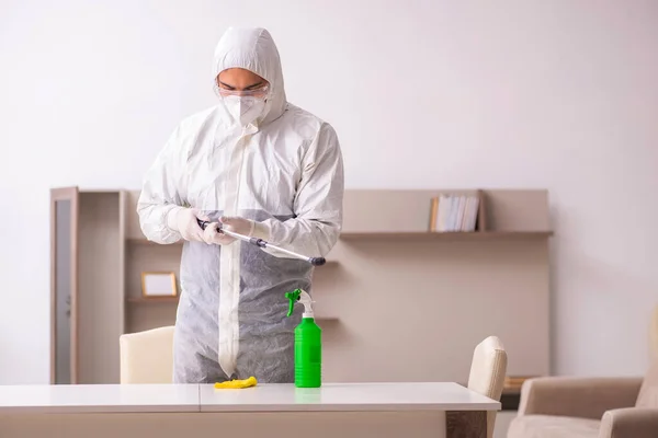 Jovem empreiteiro fazendo controle de pragas em casa — Fotografia de Stock