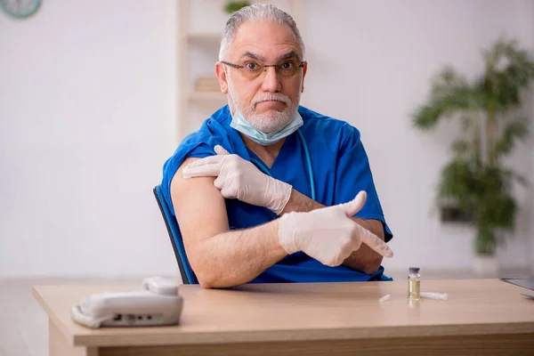 Gammal manlig läkare i vaccinationskonceptet — Stockfoto