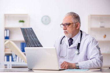 Hastanede çalışan yaşlı bir erkek radyoloji uzmanı.