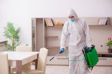Young male contractor disinfecting at home