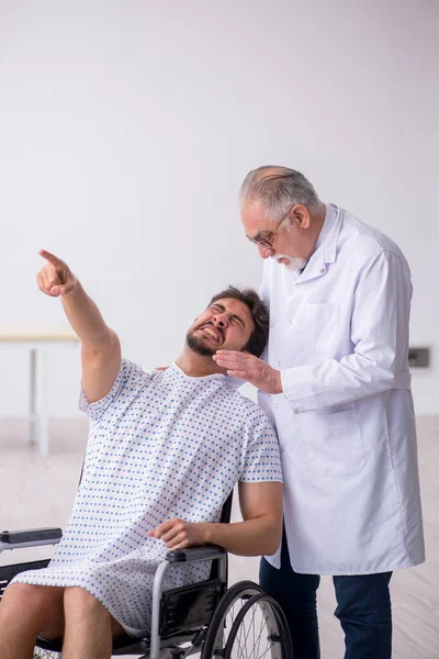 Alte männliche Arzt Psychiater untersucht jungen behinderten Patienten — Stockfoto