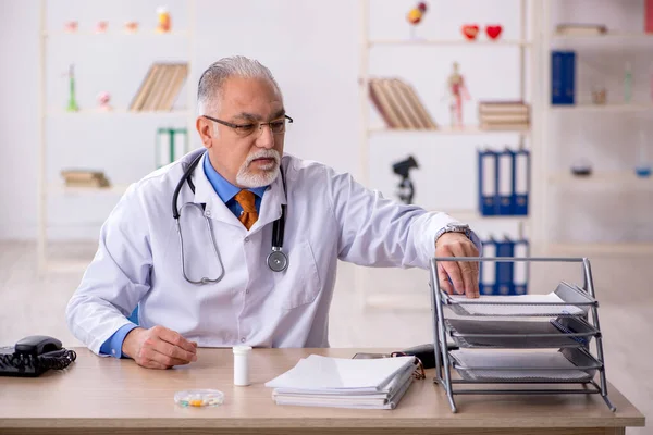 Velho médico do sexo masculino trabalhando na clínica — Fotografia de Stock