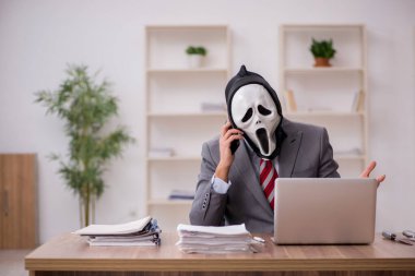 Şeytan işadamı işyerinde oturuyor.