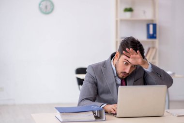 Ofiste çalışan genç bir erkek.