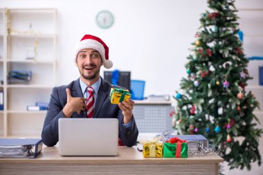 Genç erkek çalışan Noel 'i işyerinde kutluyor