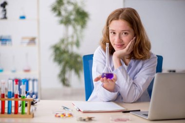 Laboratuarda çalışan genç bir kadın kimyager.