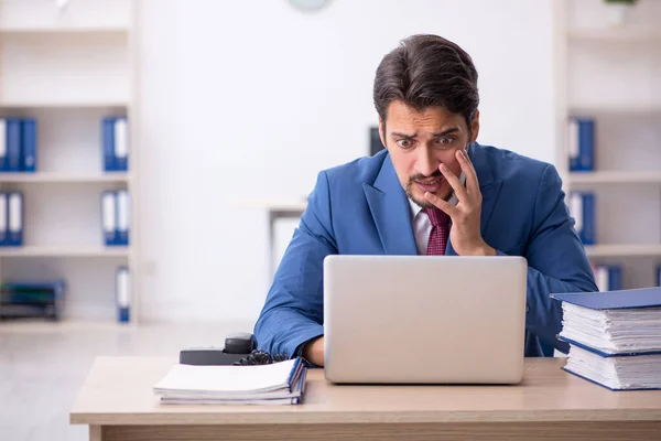 Jovem funcionário masculino infeliz com excesso de trabalho no escritório — Fotografia de Stock