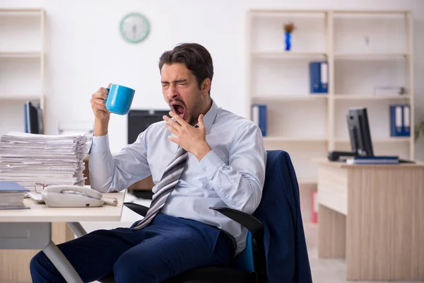Jovem funcionário do sexo masculino bebendo café durante o intervalo — Fotografia de Stock