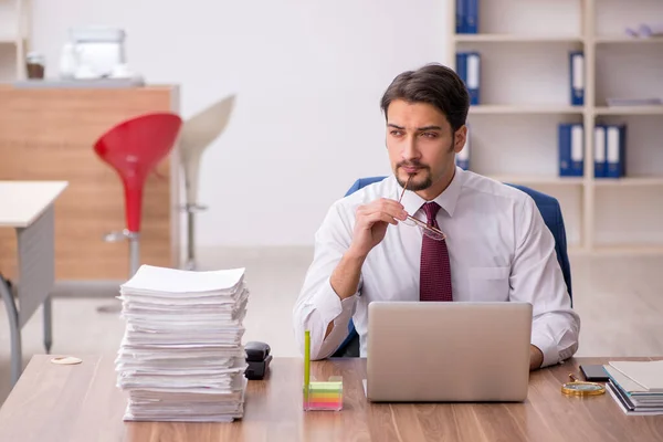 Junge männliche Mitarbeiter und zu viel Arbeit im Büro — Stockfoto