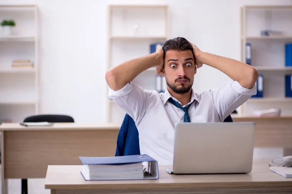 Jonge mannelijke werknemer werkzaam in het kantoor — Stockfoto