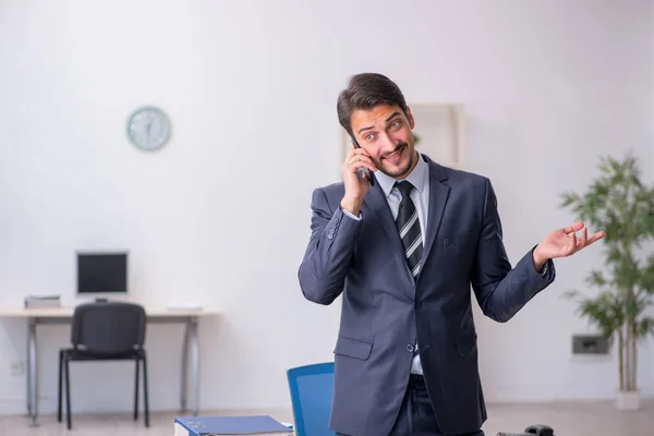 Empleado joven sentado en el lugar de trabajo — Foto de Stock