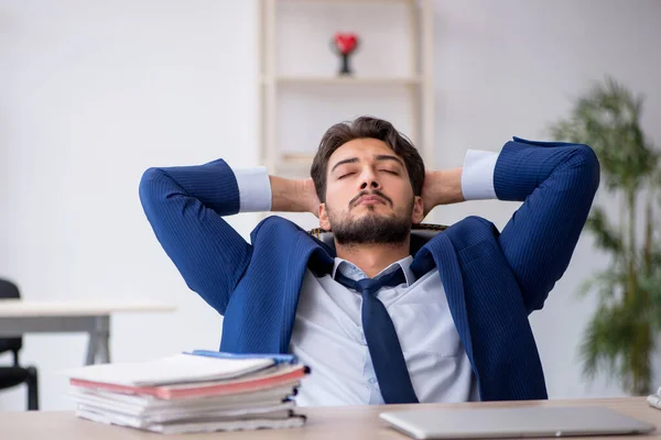 Młody mężczyzna pracownik bardzo zmęczony w biurze — Zdjęcie stockowe