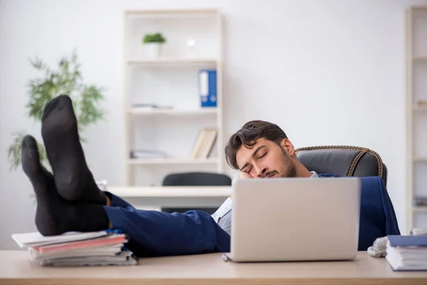 Jovem funcionário masculino extremamente cansado no escritório — Fotografia de Stock