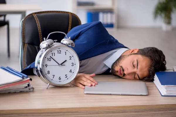 Joven empleado masculino en concepto de gestión del tiempo —  Fotos de Stock