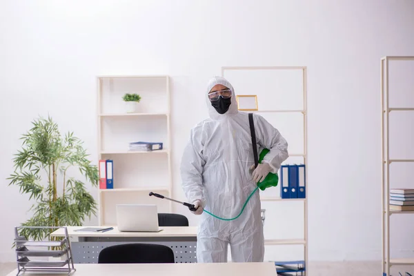 Jeune entrepreneur désinfectant son bureau pendant une pandémie — Photo