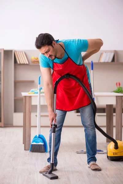 Jovem empreiteiro limpando a casa — Fotografia de Stock