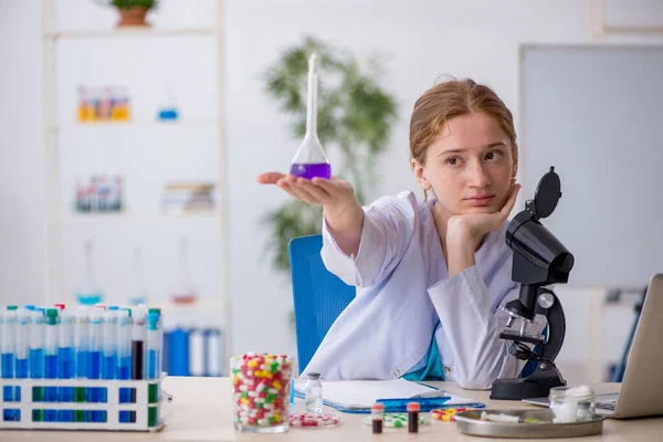 Joven química femenina en concepto de síntesis de fármacos — Foto de Stock