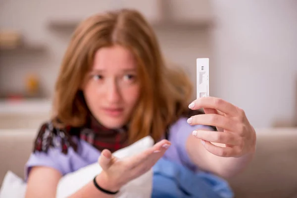 Jonge zieke vrouw die thuis zwangerschapstest houdt — Stockfoto