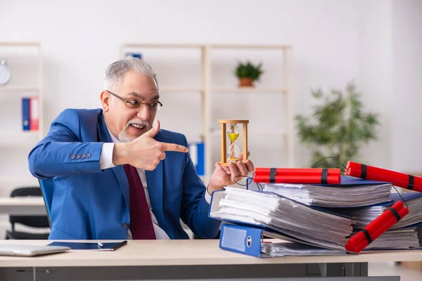 Oude mannelijke werknemer met dynamiet op kantoor — Stockfoto