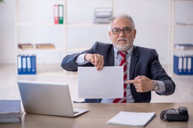 Ofiste çalışan yaşlı bir erkek.