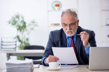 Ofiste çalışan yaşlı bir erkek.