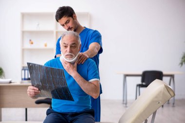 Yaşlı erkek hasta genç erkek doktor radyolojisti ziyaret ediyor.