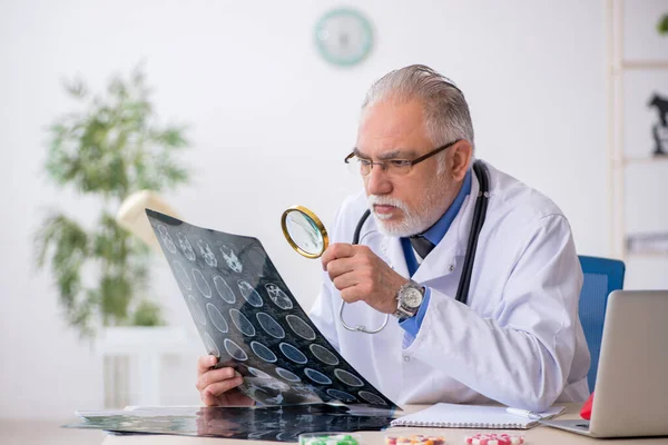 Klinikte çalışan yaşlı bir erkek radyolog. — Stok fotoğraf