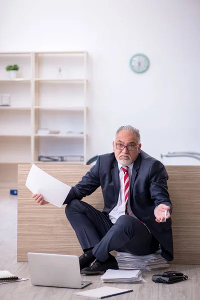 Velho empregado do sexo masculino trabalhando horas extras no escritório — Fotografia de Stock