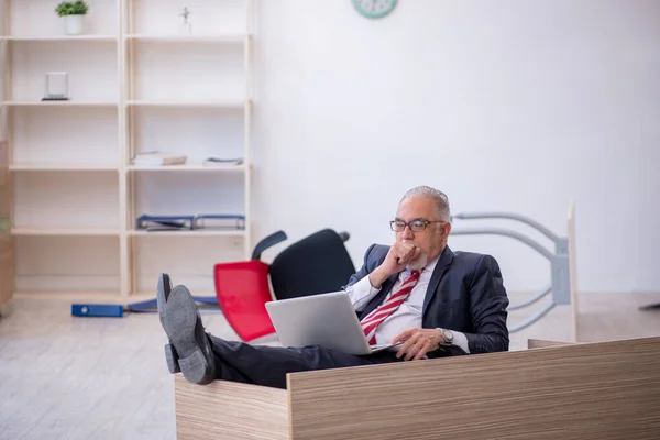 Starý muž zaměstnanec pracující přesčas v kanceláři — Stock fotografie