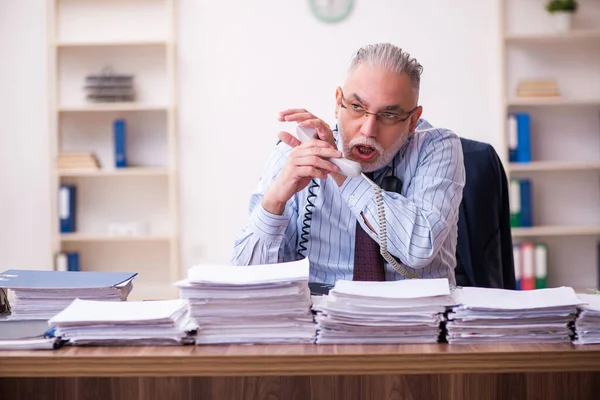 Old businessman employee unhappy with excessive work in the office — Stock Photo, Image