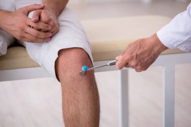 Genç erkek hasta yaşlı erkek nörologu ziyaret ediyor.