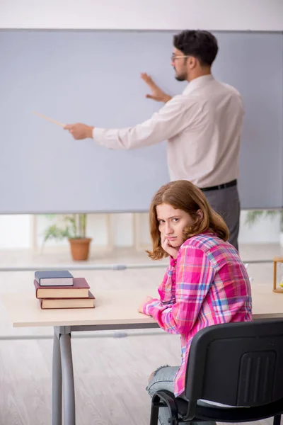 Mladý muž učitel a zrzka dívka ve třídě — Stock fotografie
