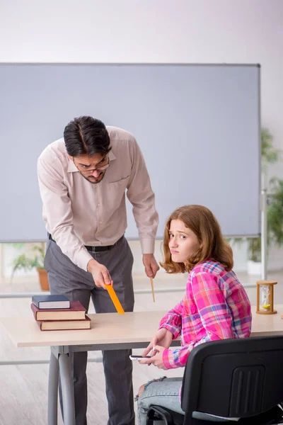 Νεαρό αρσενικό δάσκαλος και κοκκινομάλλα κορίτσι στην τάξη — Φωτογραφία Αρχείου