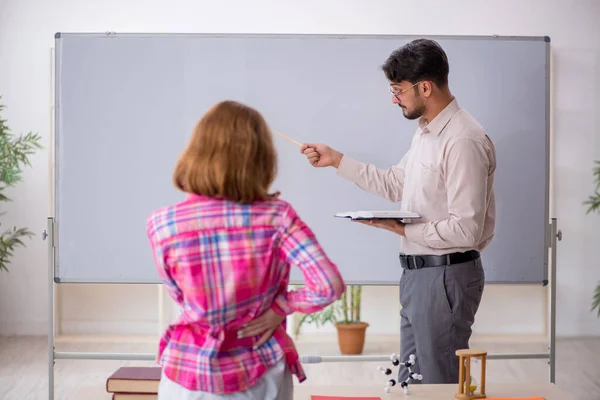 Jong man leraar en roodharige meisje in de klas — Stockfoto